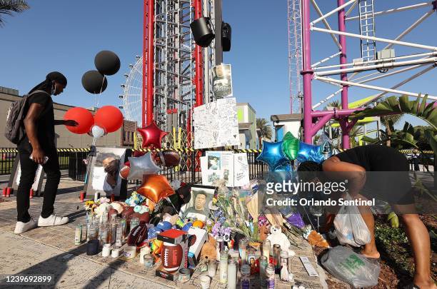 Family members and friends of Tyre Sampson leave flowers and other items at a vigil in front of the Orlando Free Fall drop tower in ICON Park in...