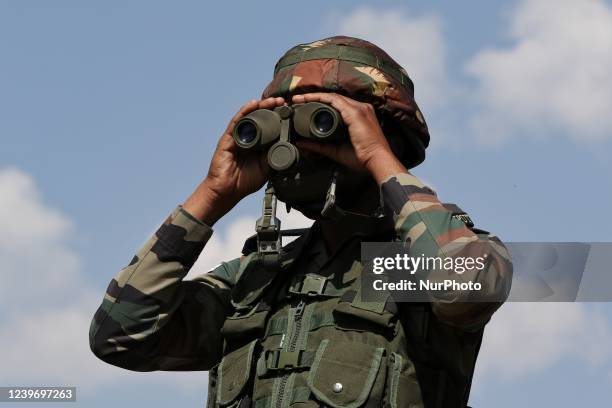 An Indian Army Soldier looks through a Binocular at a Forward Post at LoC Line Of Control in Uri, Baramulla, Jammu and Kashmir, India on 02 April...