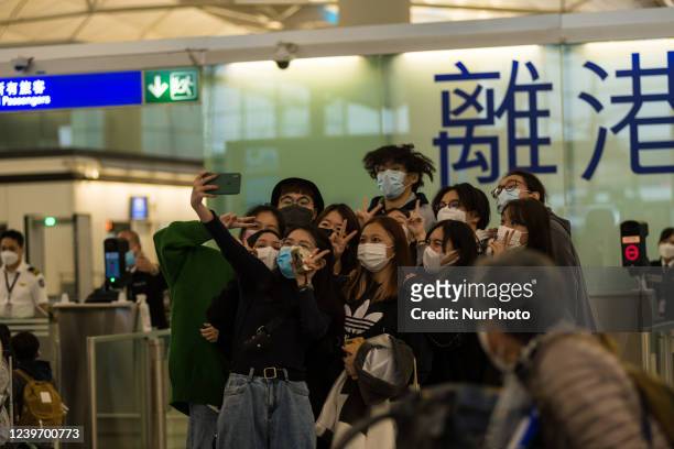 Hong Kong, China, 2 Apr 2022, Travelers and friends pose for a selfie before entering the immigration area of the departure hall in the Hong Kong...