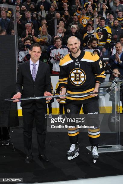 Nick Foligno of the Boston Bruins celebrates his 1000th NHL game with General Manager Don Sweeney presented a traditional Silver Stick, given to all...