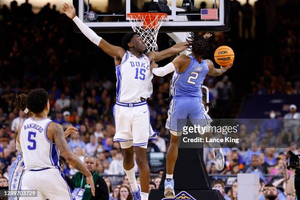 Caleb Love of the North Carolina Tar Heels goes to the basket against Mark Williams of the Duke Blue Devils during the 2022 NCAA Men's Basketball...