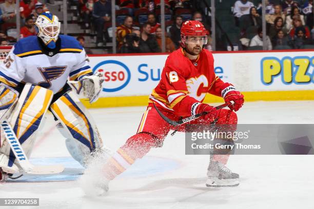 Ryan Carpenter of the Calgary Flames battles in front of the net against Ville Husso of the St Louis Blues at Scotiabank Saddledome on April 2, 2022...
