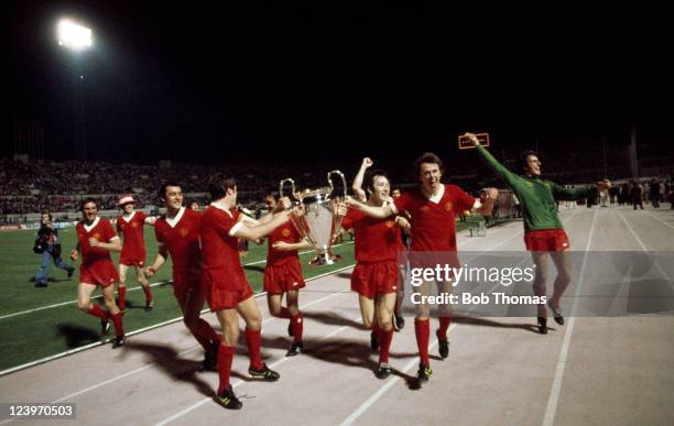 Liverpool captain Emlyn Hughes holds the trophy with Jimmy Case and Phil Neal during the lap of honour after their victory over Borussia...