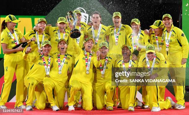 Australia's captain Meg Lanning holds the trophy as team celebrate their win after the Women's Cricket World Cup final match between England and...