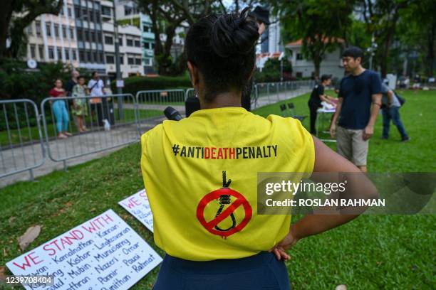 An activist looks at placards showing the names of individuals currently on death row during a protest against the death penalty at Speakers' Corner...