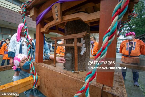 Believers look at a portable shrine with a phallus-like statue during the Kanamara Festival at Kanayama Shrine in Kawasaki on April 3, 2022. Japanese...