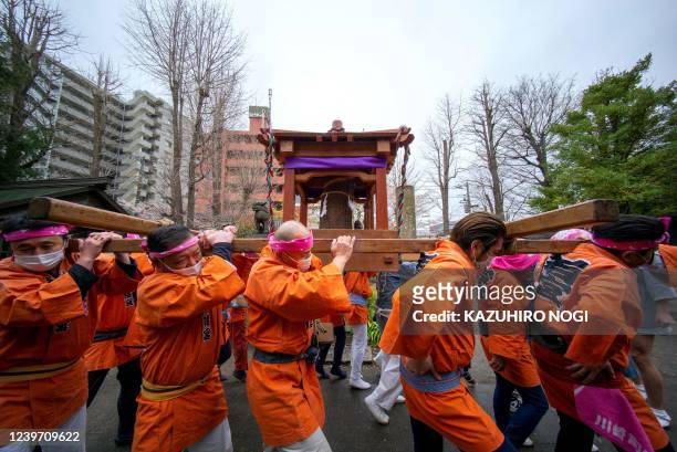 Believers carry a portable shrine with a phallus-like statue during the Kanamara Festival at Kanayama Shrine in Kawasaki on April 3, 2022. Japanese...