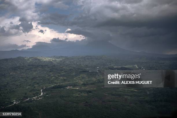This aerial photograph taken on April 1, 2022 shows Mount Mikeno in the background, a hideout of the M23/ARC armed group, and home to the last...