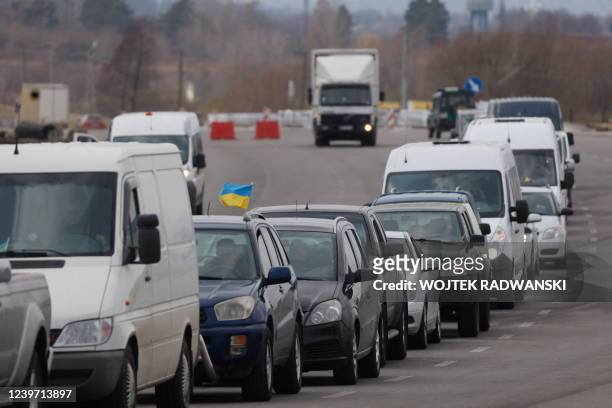 Ukrainian flag is seen on the top of a car queuing in a line of vehicles going back to Ukraine at the border crossing in Medyka, eastern Poland, on...