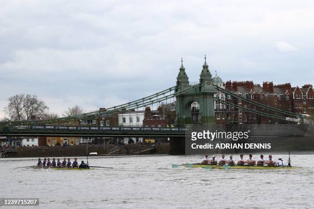 The Oxford boat leads the Cambridge boat under the Hammersmith Bridge during the 167th annual men's boat race between Oxford University and Cambridge...