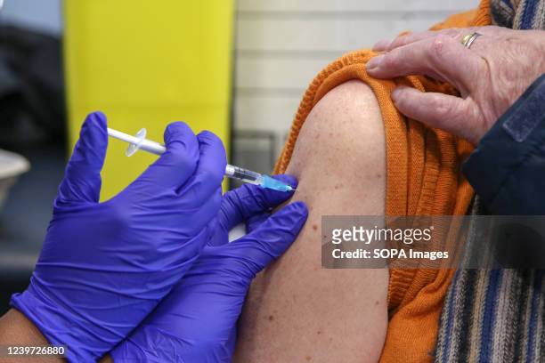 Vaccinator, administers the Pfizer COVID-19 second booster jab to a woman, at a vaccination centre in London. Older adults have been invited for a...