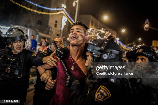 April 2022, Palestinian Territories, Jerusalem: Israeli security forces arrest a protester during clashes with Palestinians at Damascus Gate by the...