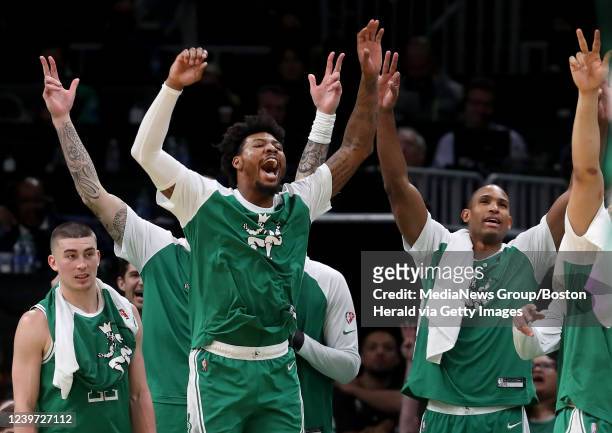 Boston Celtics' Payton Pritchard, Marcus Smart and Al Horford react as their teammates from the bench start sinking three pointers during the 4th...