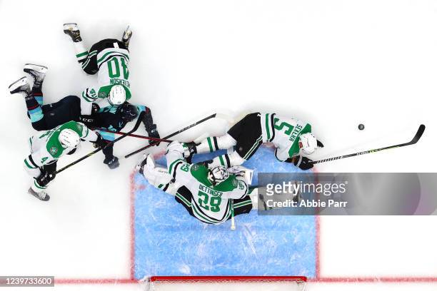 Jake Oettinger, Miro Heiskanen, Jacob Peterson and Andrej Sekera of the Dallas Stars collide while defending the goal against Jared McCann of the...