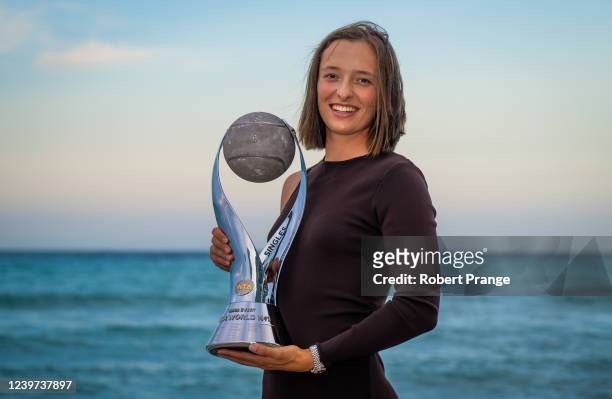 April 02: Iga Swiatek of Poland poses with the Chis Evert WTA World No.1 trophy on Hollywood Beach after winning the womens single final on day 13 of...