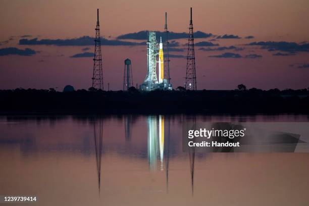 In this handout photo provided by NASA, NASA's Space Launch System rocket with the Orion spacecraft aboard is seen at sunrise atop a mobile launcher...