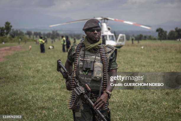 Soldier of the Democratic Republic of Congo's armed forces holds his weapon during a security patrol around the Kiwanja airfield days after clashes...