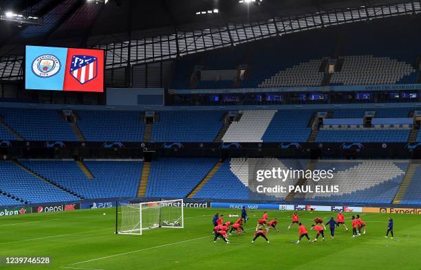 Atletico Madrid players huddle on the pitch as they attend a training session at the Etihad Stadium in Manchester, north west England, on April 4 on...