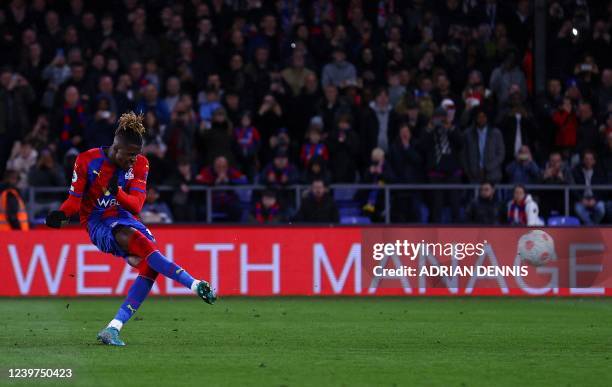 Crystal Palace's Ivorian striker Wilfried Zaha scores the team's third goal from the penalty spot during the English Premier League football match...