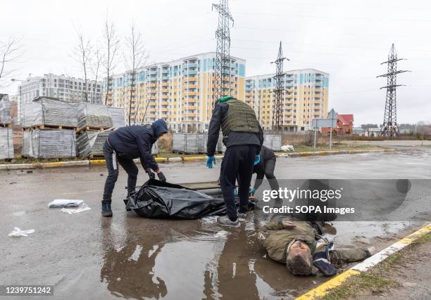 Volunteers remove bodies of civilians killed in the Russian invasion lie on the streets of Bucha.