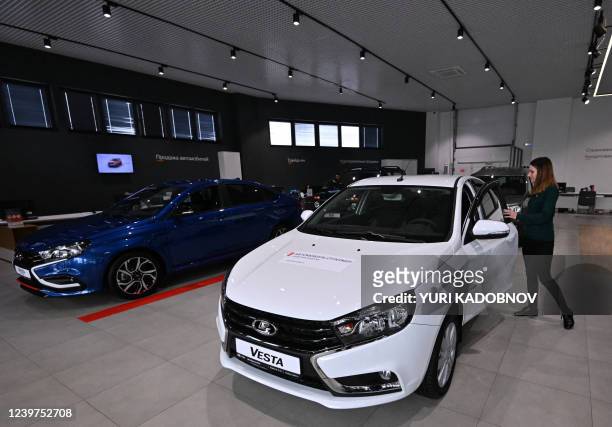 Manager opens the door of a Lada Vesta car at a Lada car dealership showroom in Tolyatti, also known as Togliatti, on April 1, 2022. For generations...