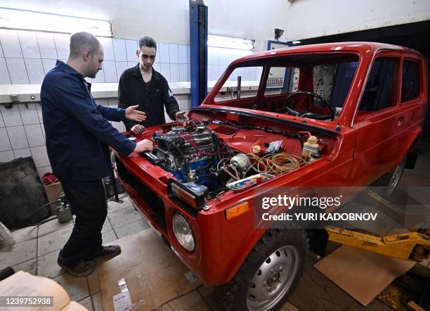 Sergei Diogrik , the head of the Lada History Club, and his assistant Kamil restore an 80s Lada Niva, a legendary four-wheel drive car, in their...
