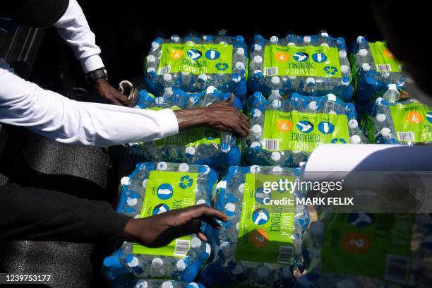 Members of Operation Good grab cases of water to hand out in Jackson, Mississippi on March 24, 2022. - Every morning, 180 students at a school in...