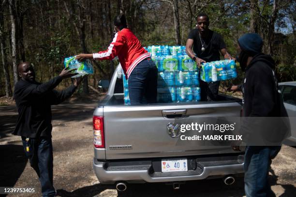 Members of Operation Good distribute cases of water in an apartment complex in Jackson, Mississippi on March 24, 2022. - Every morning, 180 students...