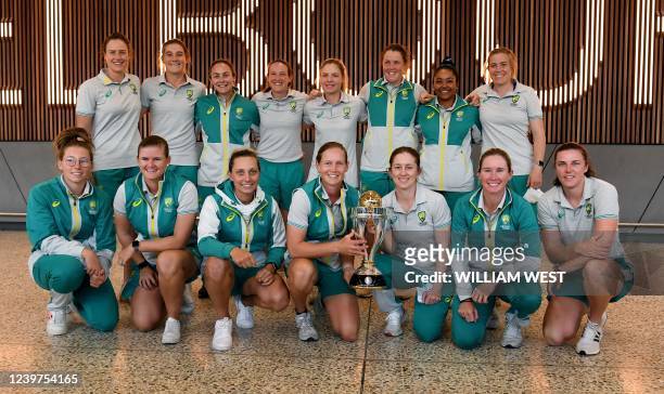 The Australian women's cricket team poses with the trophy at Melbourne Airport on April 5, 2022 after arriving home from winning the World Cup 2022...