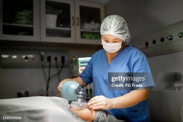 anesthesist/verpleegster die patiënt aan chirurgie bij werkende ruimte in het ziekenhuis voorbereidt - verdovingsmiddel stockfoto's en -beelden