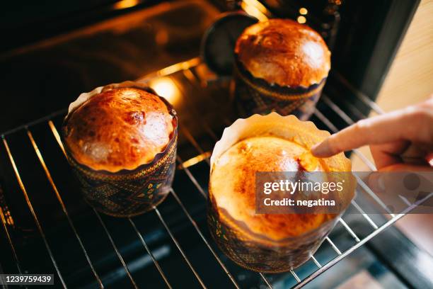 close-up of the hand of young man testing baked pannetone cakes - easter cake stock pictures, royalty-free photos & images