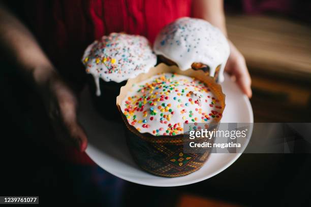 hands of the young man holding baked pannettone on the white plate - easter cake stock pictures, royalty-free photos & images