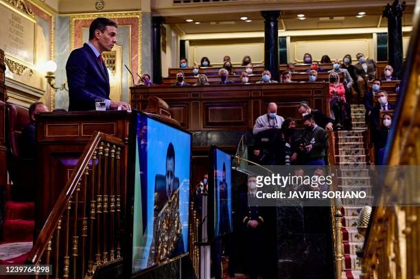 Spain's Prime Minister Pedro Sanchez delivers a speech as Ukrainian President Volodymyr Zelensky appears on a screen to address the lower house by...
