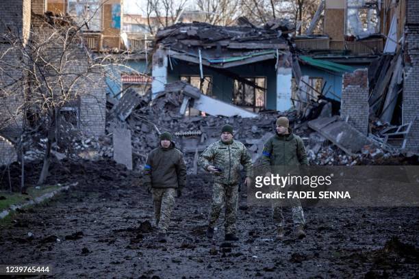 Servicemen walk near a damaged school, next to a police building in Kramatorsk, Donbas Region of eastern Ukraine on April 5, 2022.