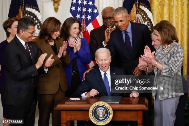 President Joe Biden gets a pat on the back from former President Barack Obama after Biden signed an executive order aimed at strengthening the...