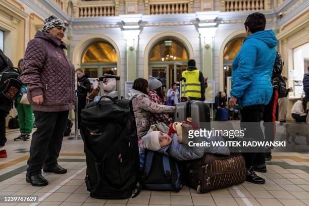 Tania, laying on the luggage, waits with her family from Donetsk region for their train to Prague, at the railway station in Przemysl, south-eastern...