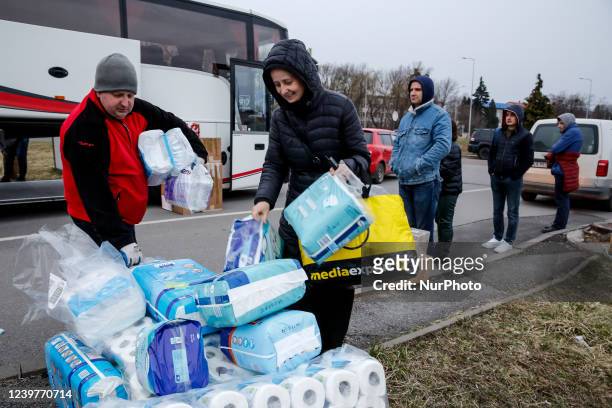 Maciej Oszal helps sister Anna to carry hygiene supplies from a coach boot delivered to Lviv, Ukraine by Abdar travel agency from Krakow, Poland as...