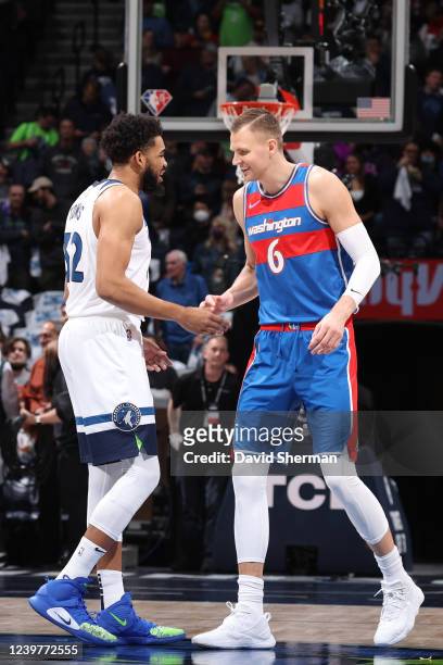 Karl-Anthony Towns of the Minnesota Timberwolves hi-fives Kristaps Porzingis of the Washington Wizards before the game on April 5, 2022 at Target...