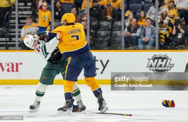Jeremy Lauzon of the Nashville Predators drops the gloves against Brandon Duhaime of the Minnesota Wild during an NHL game at Bridgestone Arena on...