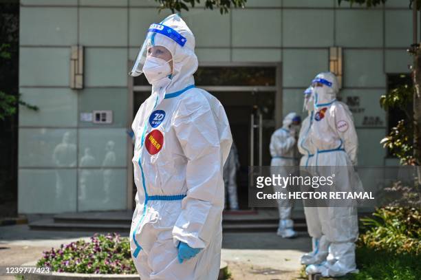 Workers and volunteers stand in a compound where residents are being tested for the Covid-19 coronavirus during the second stage of a pandemic...