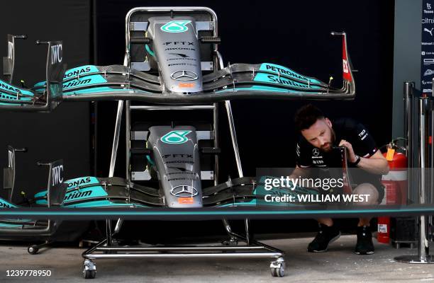 Mercedes crew member inspects the front spoilers at the Albert Park Circuit in Melbourne on April 6 ahead of the 2022 Formula One Australian Grand...