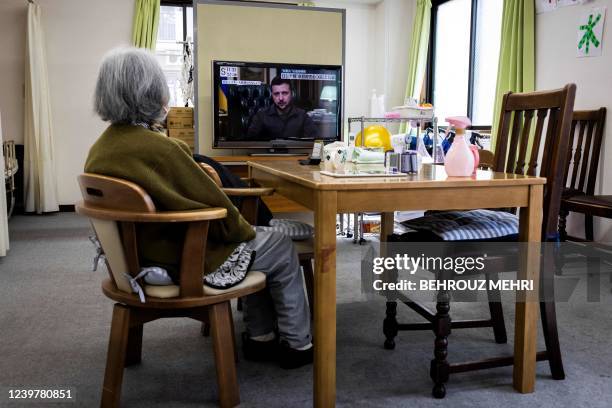 An elderly woman watches television showing a news report of Ukrainian President Volodymyr Zelensky, at a day care facility for senior citizens in...
