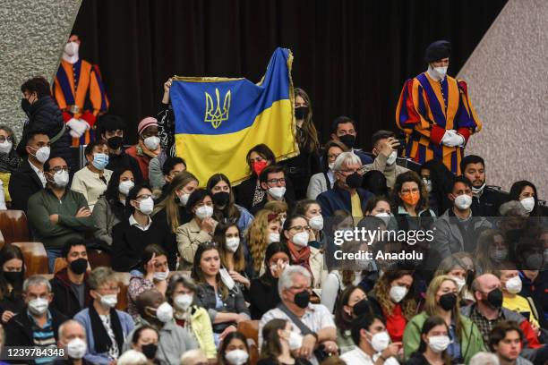 Faithful hold an Ukrainian flag as Pope Francis, not pictured, attends his weekly general audience in the Paul VI hall at the Vatican City Vatican,...