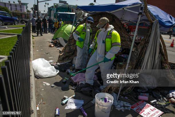 Los Angeles , CA L.A. Sanitation Bureau crew clean up a homeless encampment on the sidewalk along Hollywood Blvd. On Tuesday, April 5, 2022 in Los...
