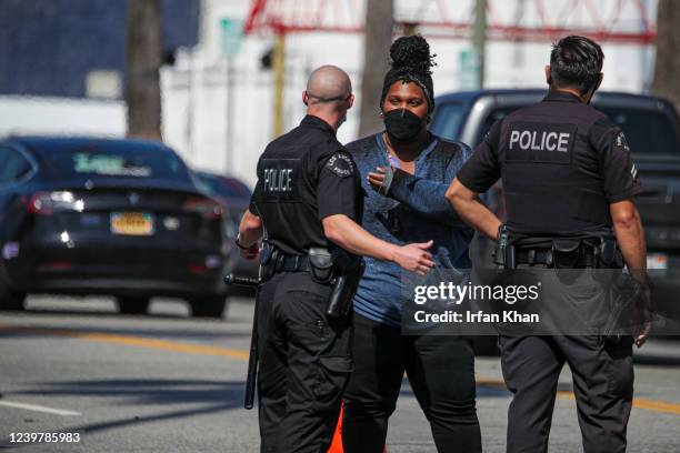 Los Angeles , CA LAPD officers keep a Street Watch activist away as L.A. Sanitation Bureau cleanup crew remove homeless encampment on the sidewalk...