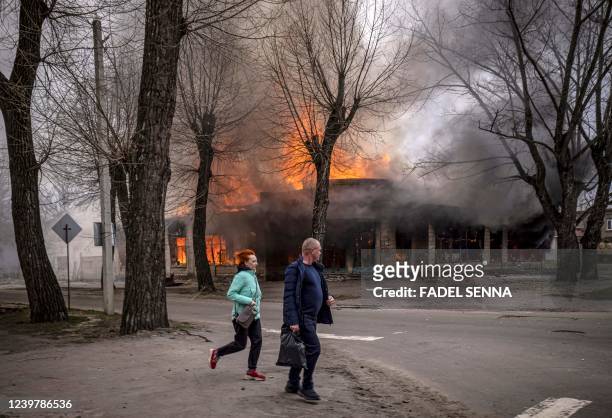 Residents run near a burning house following a shelling Severodonetsk, Donbass region, on April 6 as Ukraine tells residents in the country's east to...