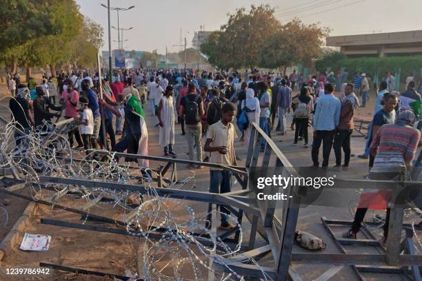 Sudanese protesters break through barbed wire blockades outside the parliament building in Omdurman on April 6 during a rally against military rule...