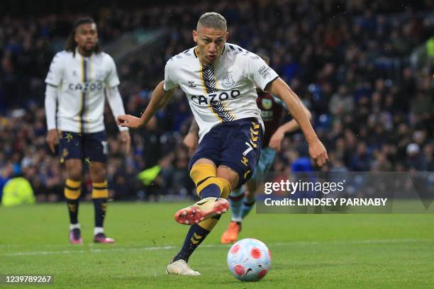 Everton's Brazilian striker Richarlison scores their first goal from the penalty spot during the English Premier League football match between...