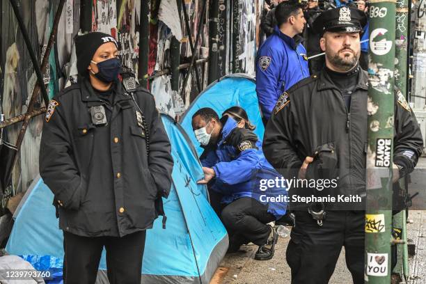 Members of the New York City police work with the Department of Sanitation to clear a homeless encampment near Tompkins Square Park on April 6, 2022...