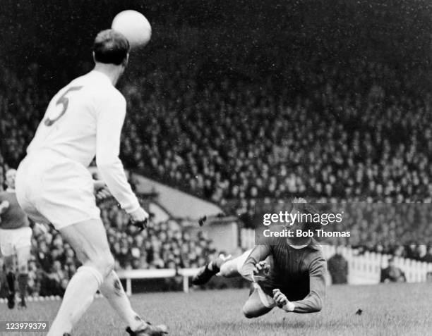 Manchester United striker Denis Law dives to head the ball watched by Leeds United defender Jack Charlton during the First Division match at Old...